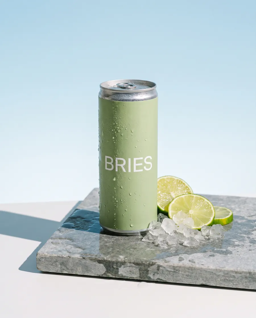 Can of soft drink on wet stone in bright sunlight