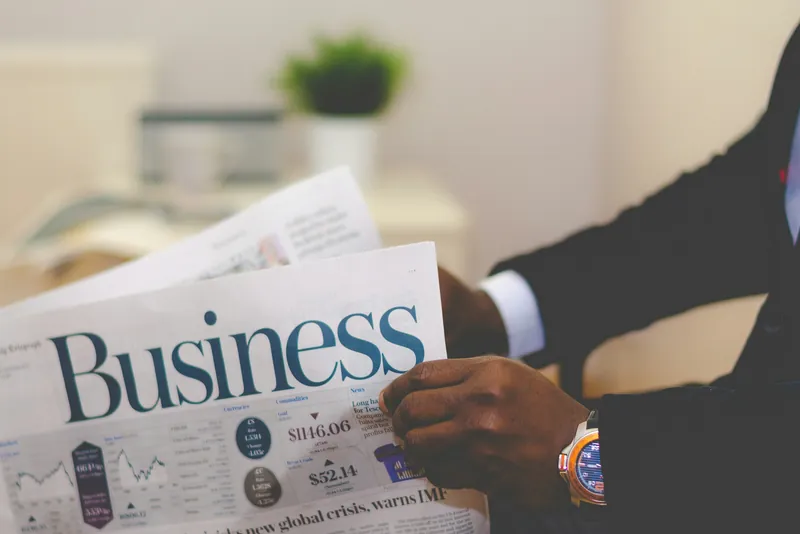 A man in a suit reading the business pages of a newspaper